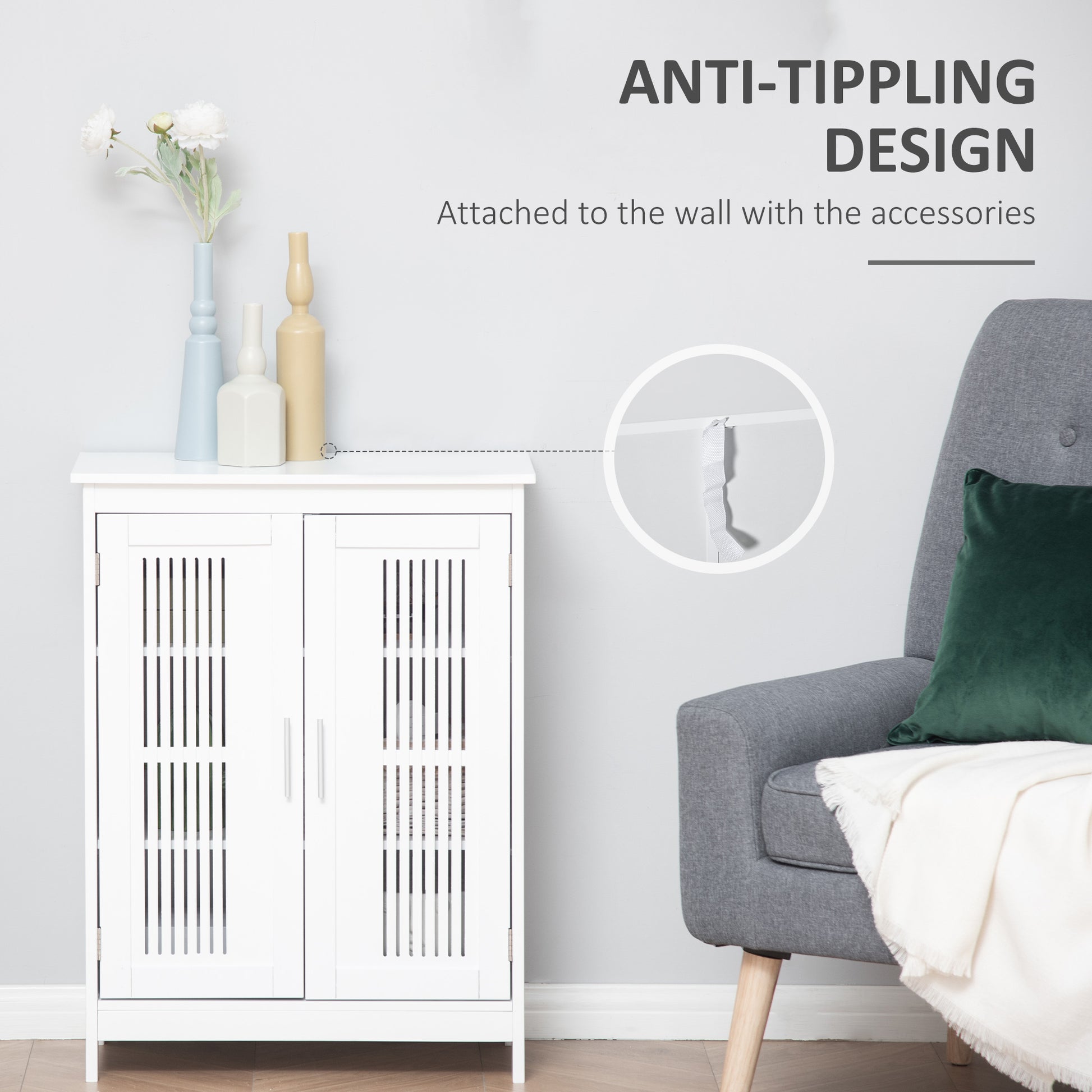 White wooden cabinet with anti-tip wall strap, next to a grey armchair and decorative vases.