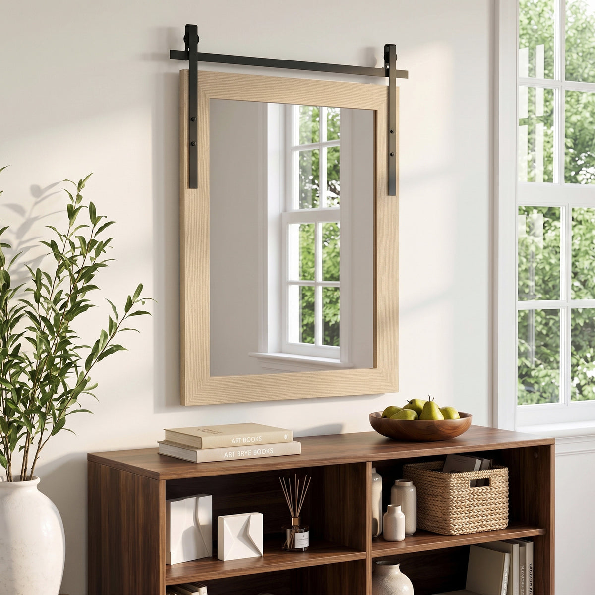 Wall mirror with wood-look border and black metal hardware above a console table