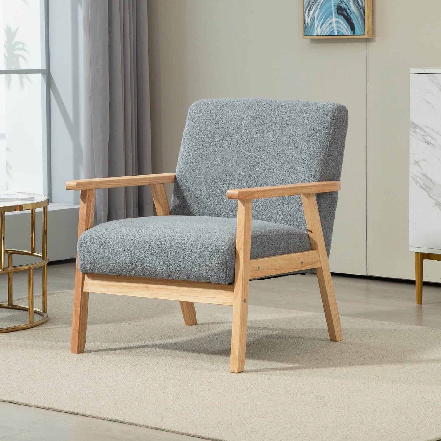 Grey upholstered accent chair with wide seat, curved arms, and light wood frame