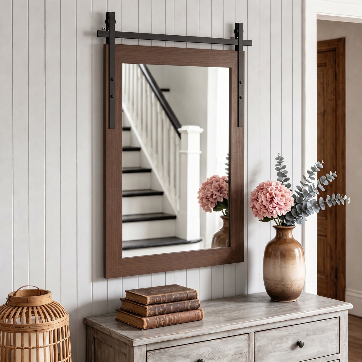 Rectangular dark brown wall mirror with black metal mounting bars above a dresser