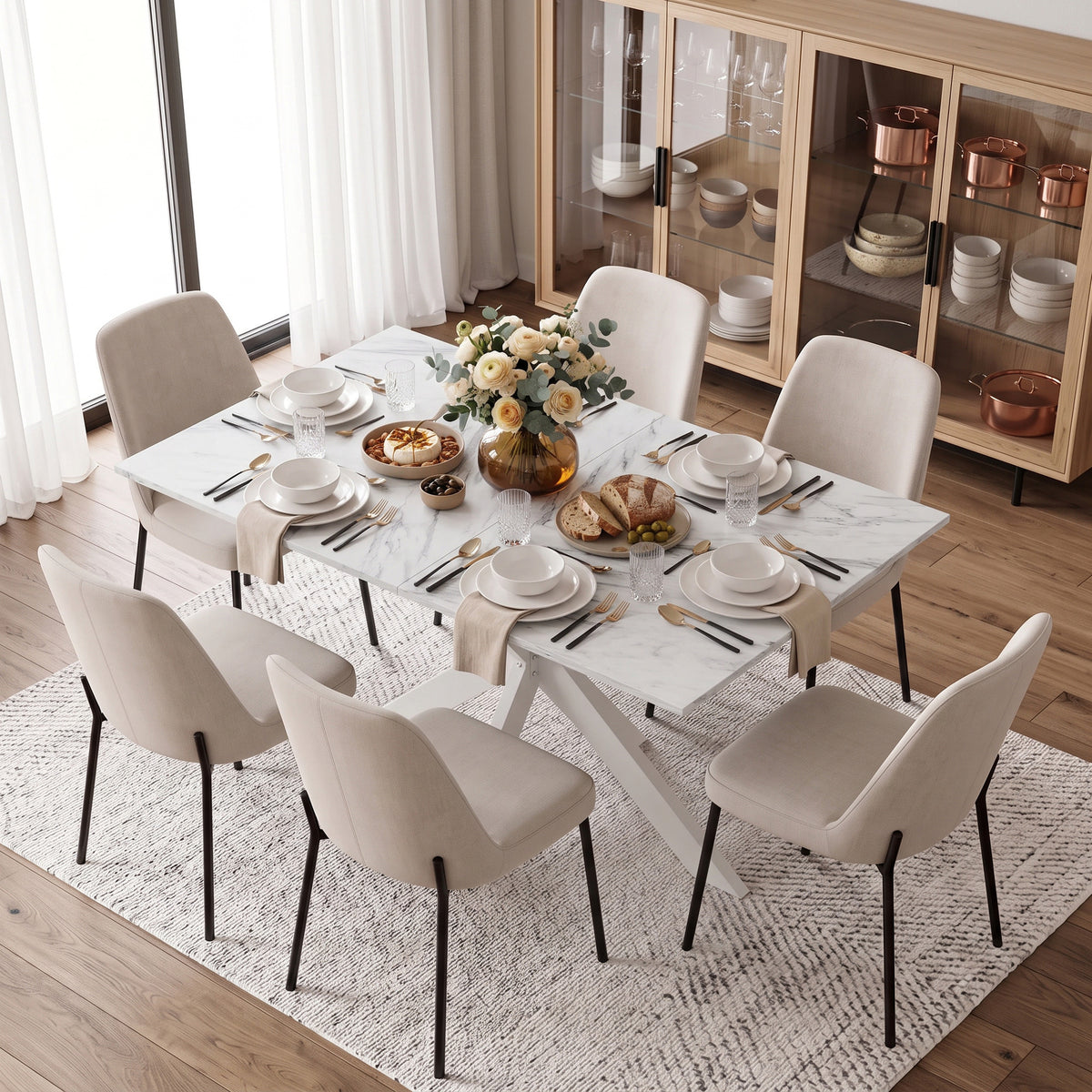 Extendable dining table with white marble-look top surrounded by six cream dining chairs
