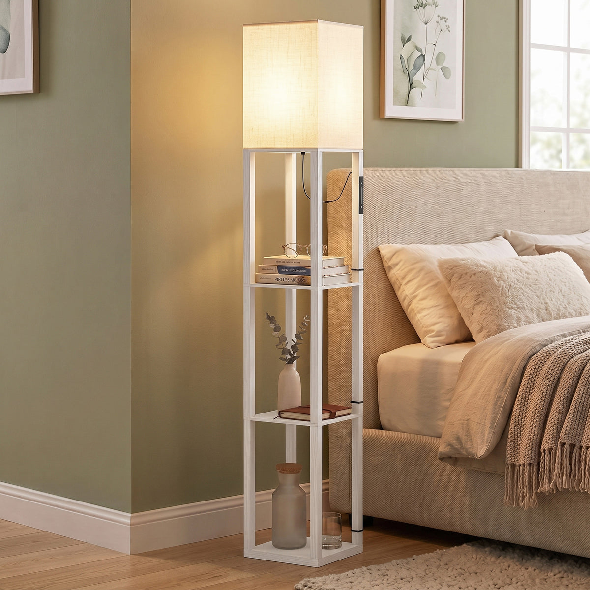 White standing floor lamp with three open shelves next to bed, soft warm glow