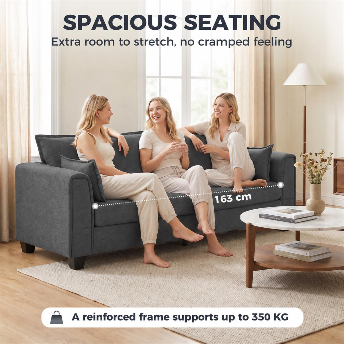 Dark grey 3-seater sofa with rounded padded arms and roomy seating, three people seated.