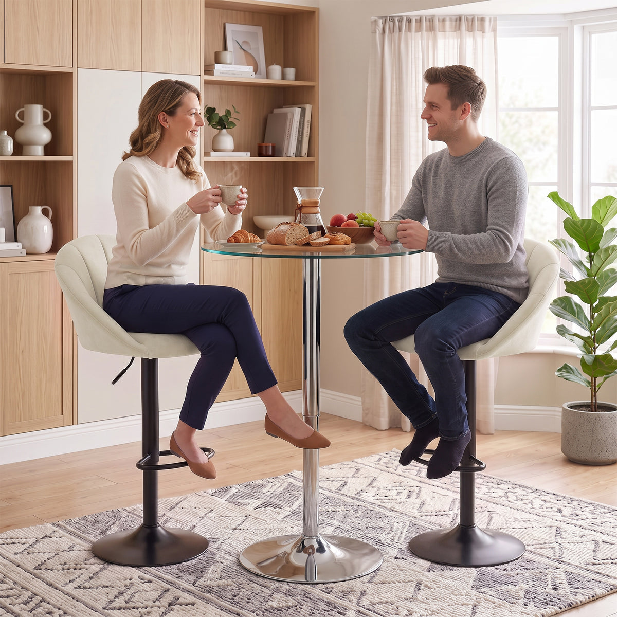 Two cream upholstered swivel bar stools with padded backs, black bases, and footrests at counter