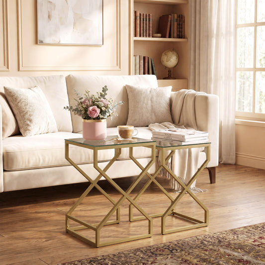 Nesting side table set with tempered glass tops and cross-brace steel legs, gold tone.
