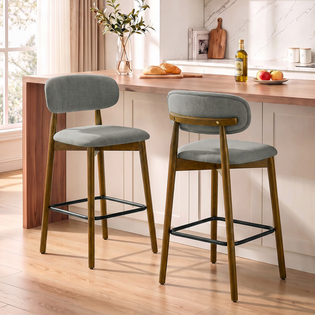 Set of 2 grey bar stools with rounded seat, curved back, and black footrest rings