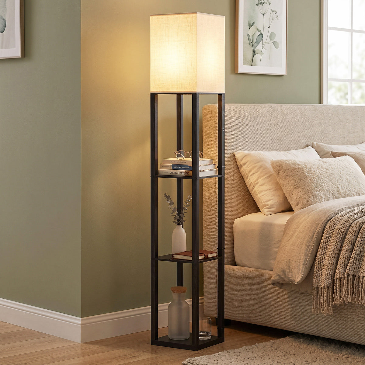 Black floor lamp with 3-tier shelves and glowing fabric shade near sofa