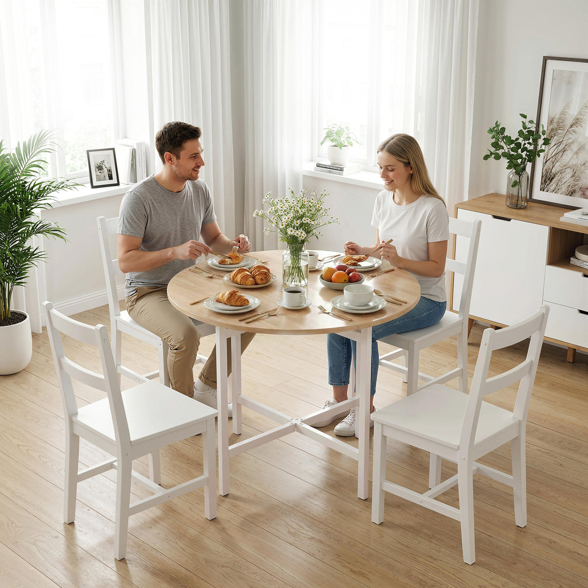 Natural wood folding dining table with round tabletop and four chairs in a room