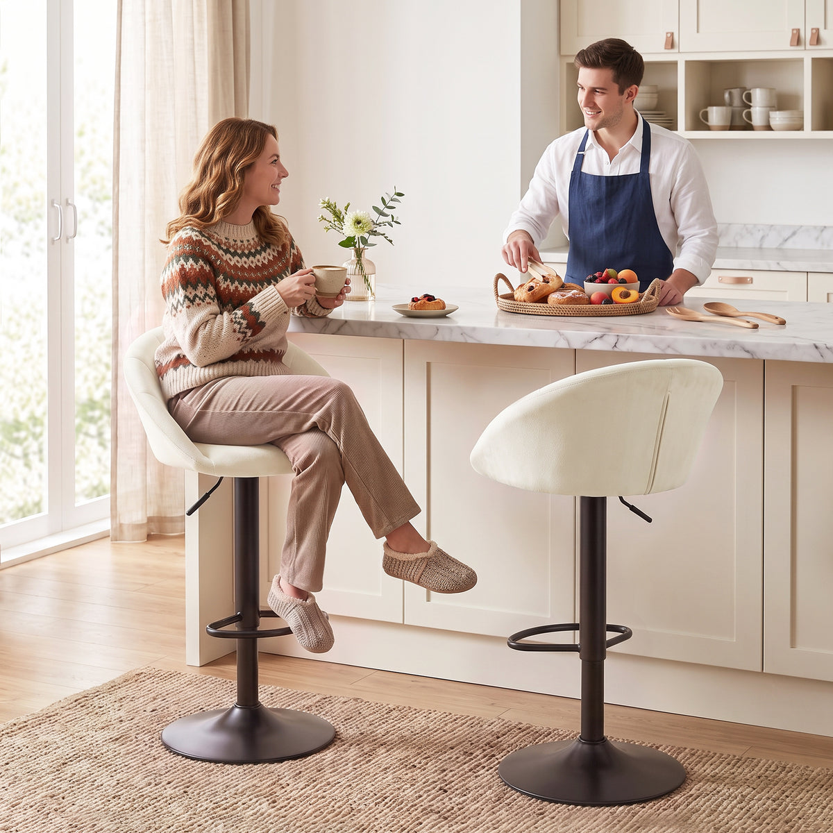 Set of two cream upholstered bar stools with padded backs, swivel bases, and footrests