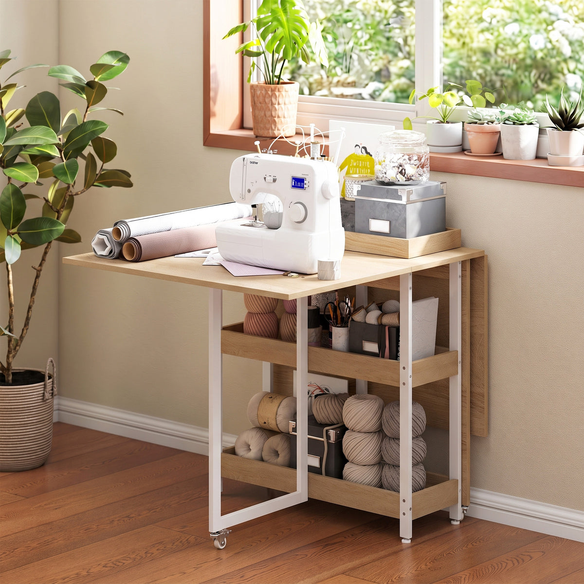 Light wood drop-leaf dining table with white metal frame and open shelves for supplies