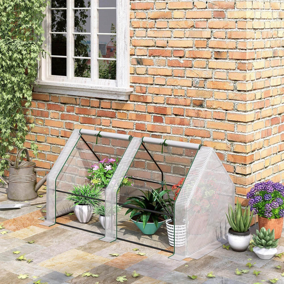 Small white-framed greenhouse with clear PE mesh panels and roll-up door openings