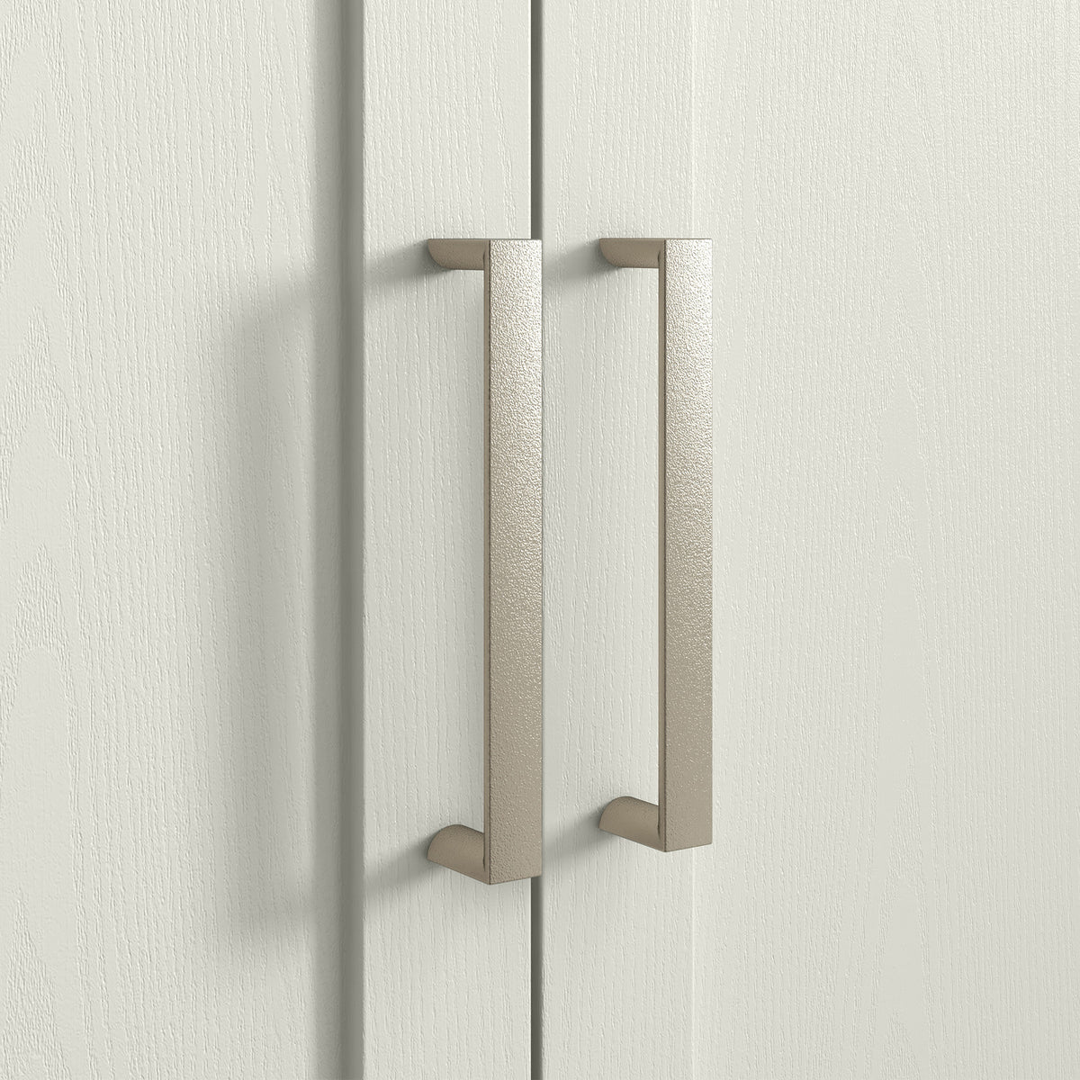 Cream cabinet doors with arched panels and curved metal pull handles