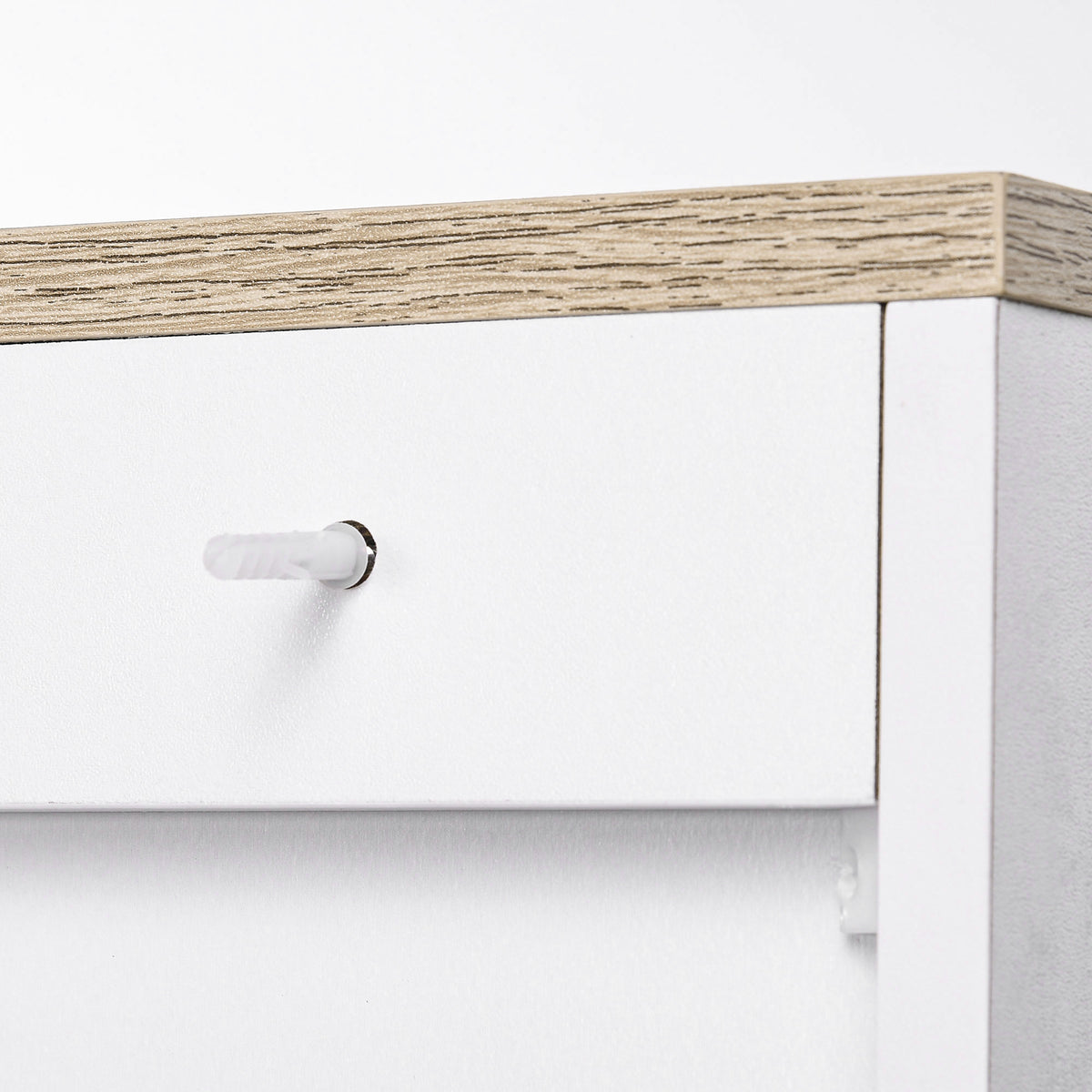 Close-up of white cabinet interior with metal handle and light wood top