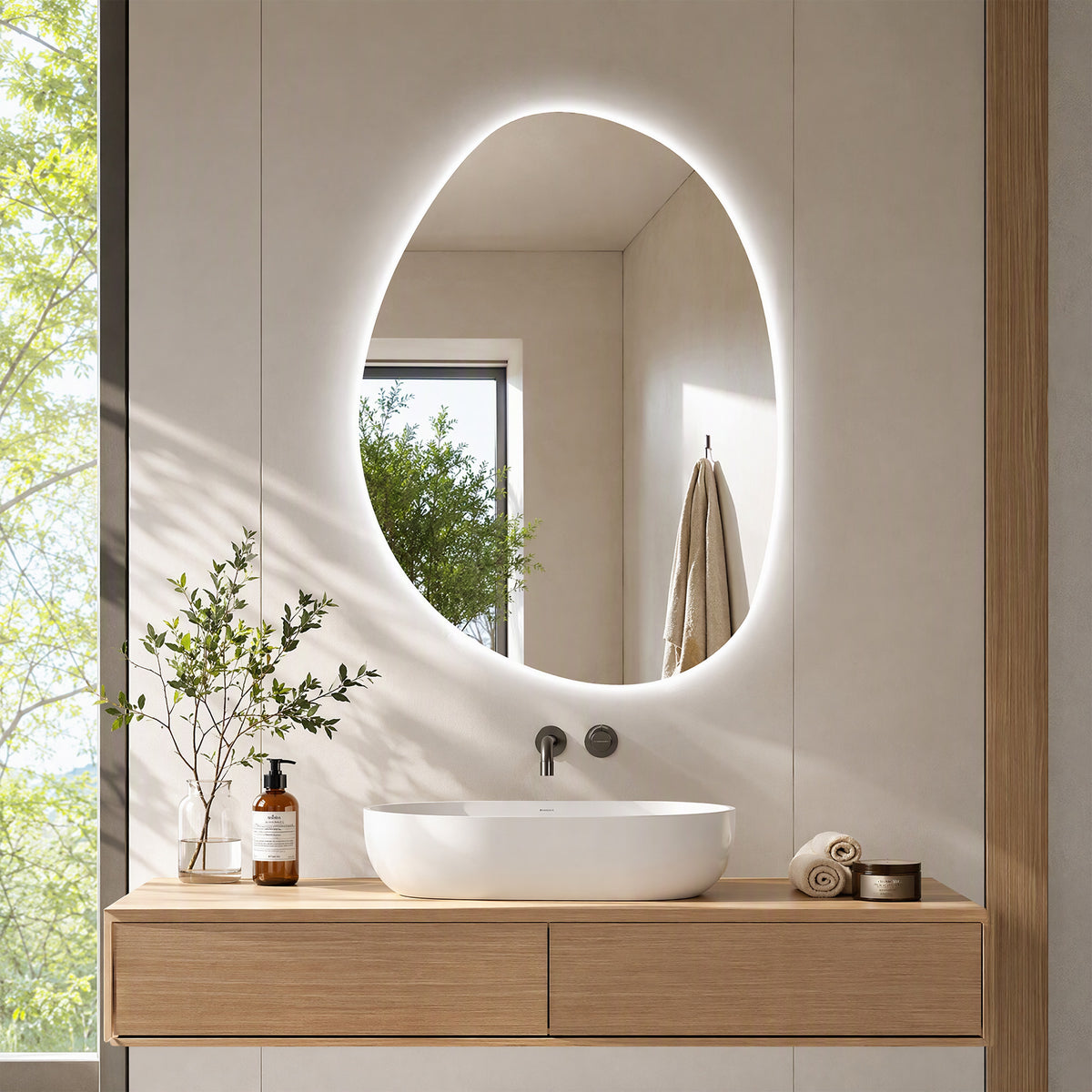 Oval illuminated LED bathroom mirror mounted above sink