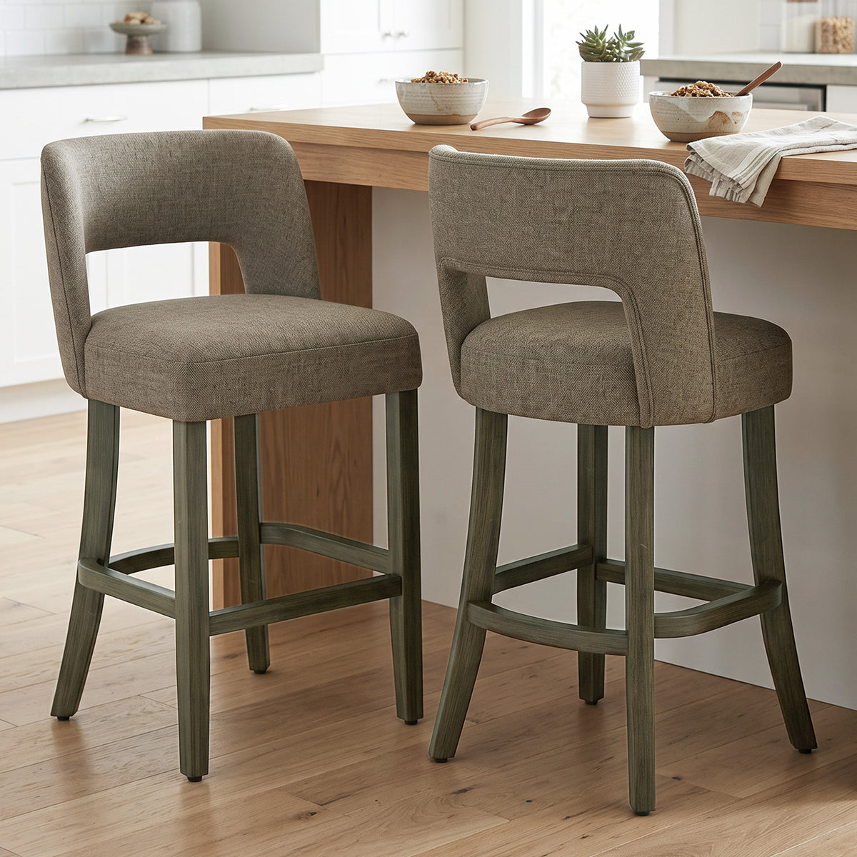 Set of 2 bar stools with curved backrests, dark fabric seats, and footrest rails