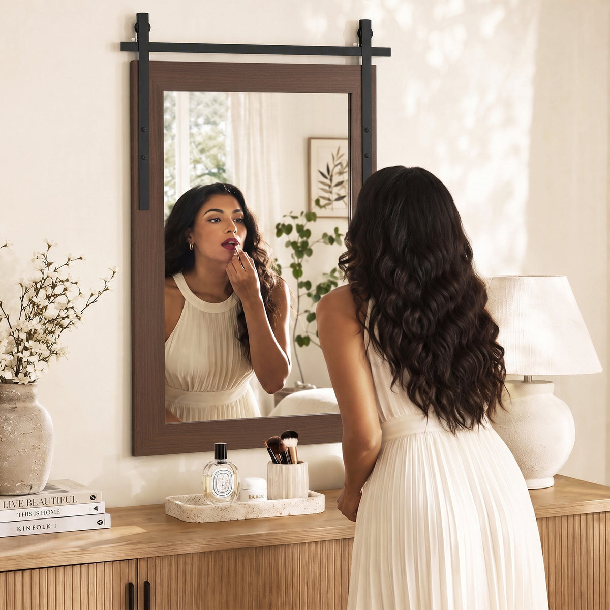 Person using farmhouse wall mirror with dark brown frame and black mounting hardware
